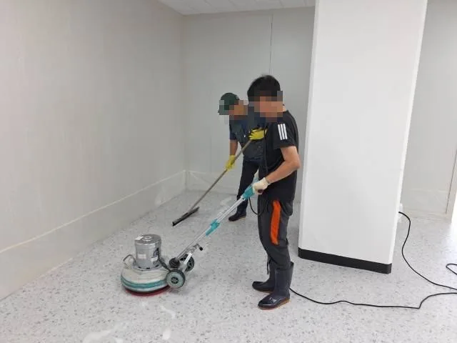 센터 현장 · 작업자가 장비로 바닥을 세척하는 모습